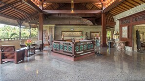 A spacious lobby with a high ceiling, polished stone floor, and traditional wooden furniture. - Bali Spirit Hotel & Spa (Ubud)