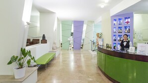 Un moderno vestíbulo de hotel con mostrador de recepción, zona de estar y exhibición de licores.