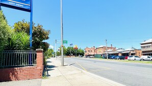 A Comfort Inn & Suites sign, a street with cars, and a clear blue sky.