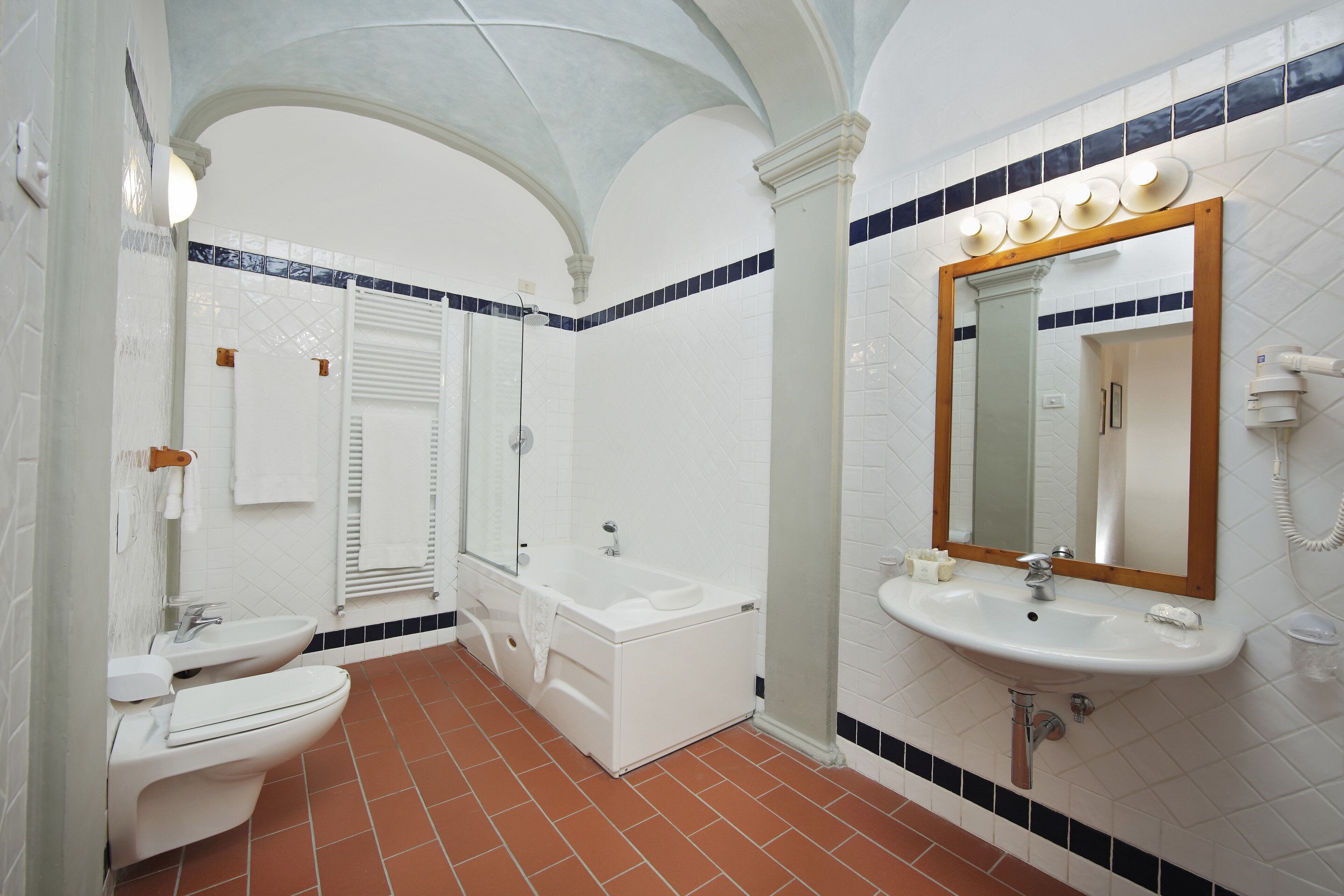 A bathroom with a toilet, sink, and bathtub.