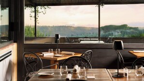 Un restaurante con una mesa para dos, con vistas a un paisaje pintoresco.