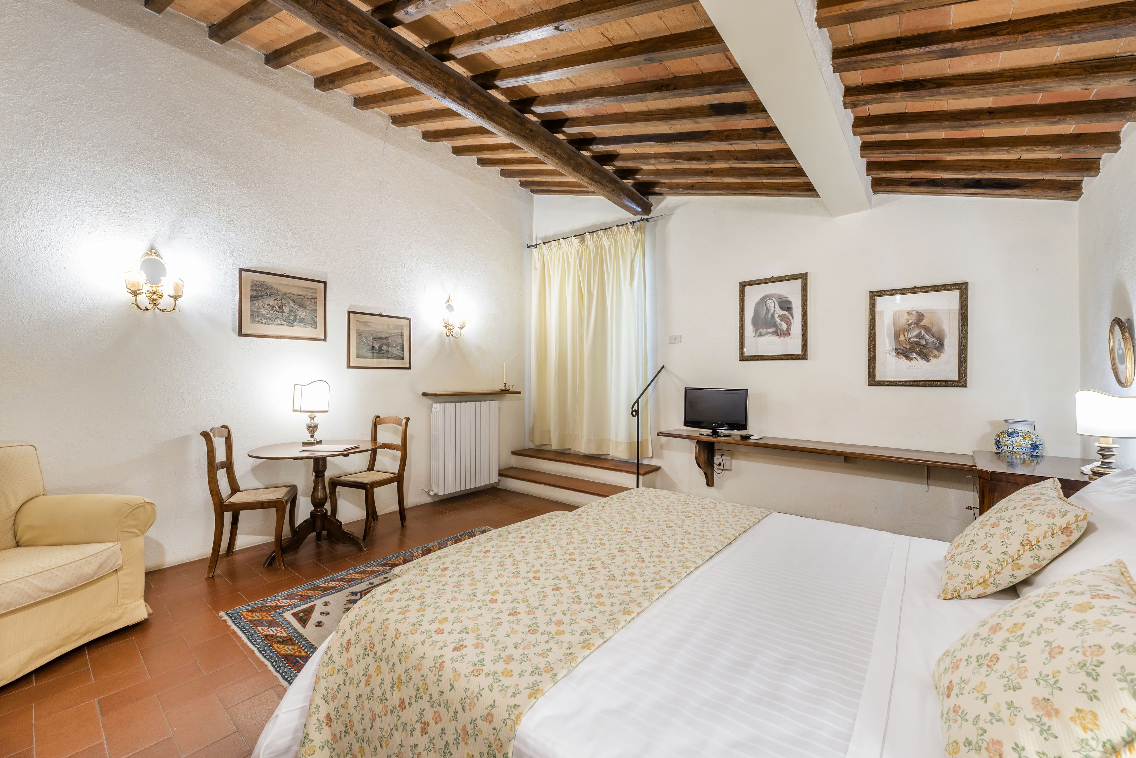 Un dormitorio con cama, escritorio, silla y sofá.