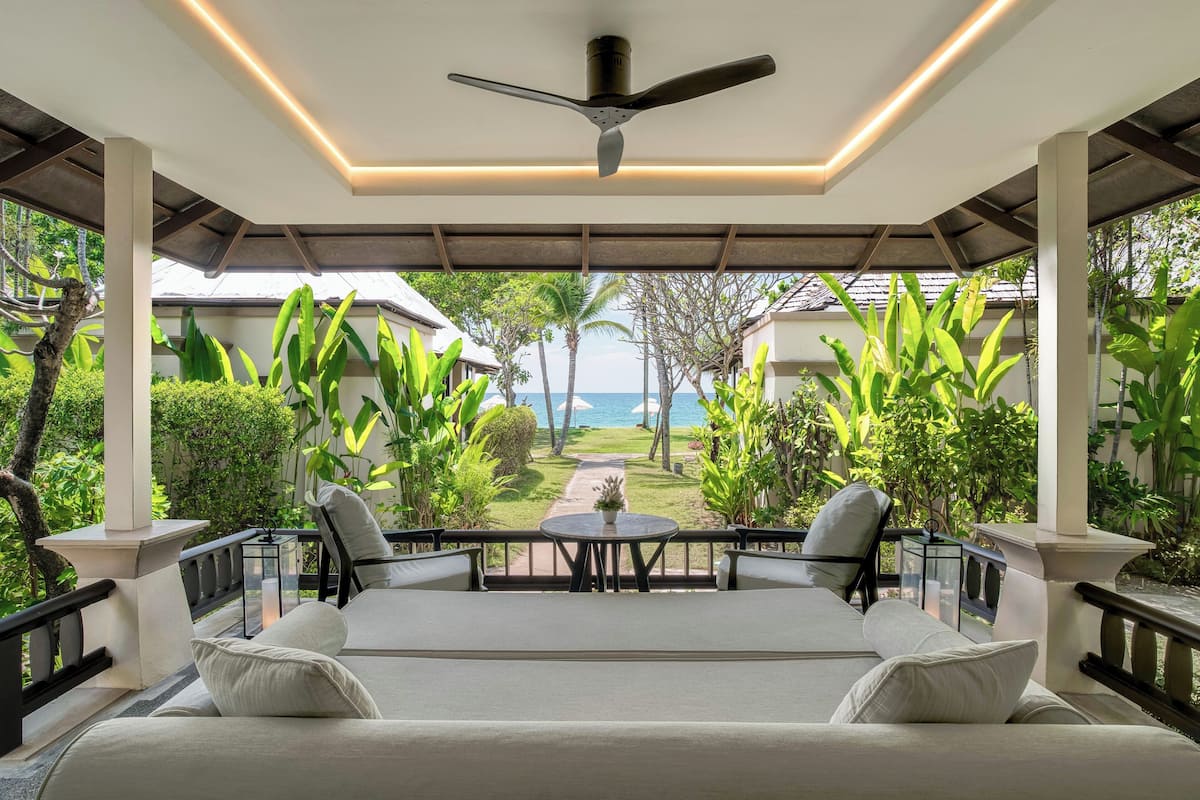 A covered outdoor seating area with a ceiling fan, a table, and chairs.