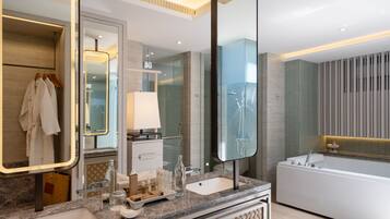 A modern bathroom with a large mirror, a bathtub, a sink, and a vanity area.
