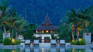 A resort with a pool, palm trees, and a building with a pointed roof. - Layana Resort and Spa - Adult Only (Ko Lanta)