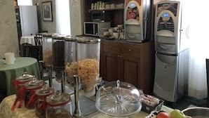 A kitchen with a microwave, refrigerator, and various food containers. - Hotel Giglio (Florence)