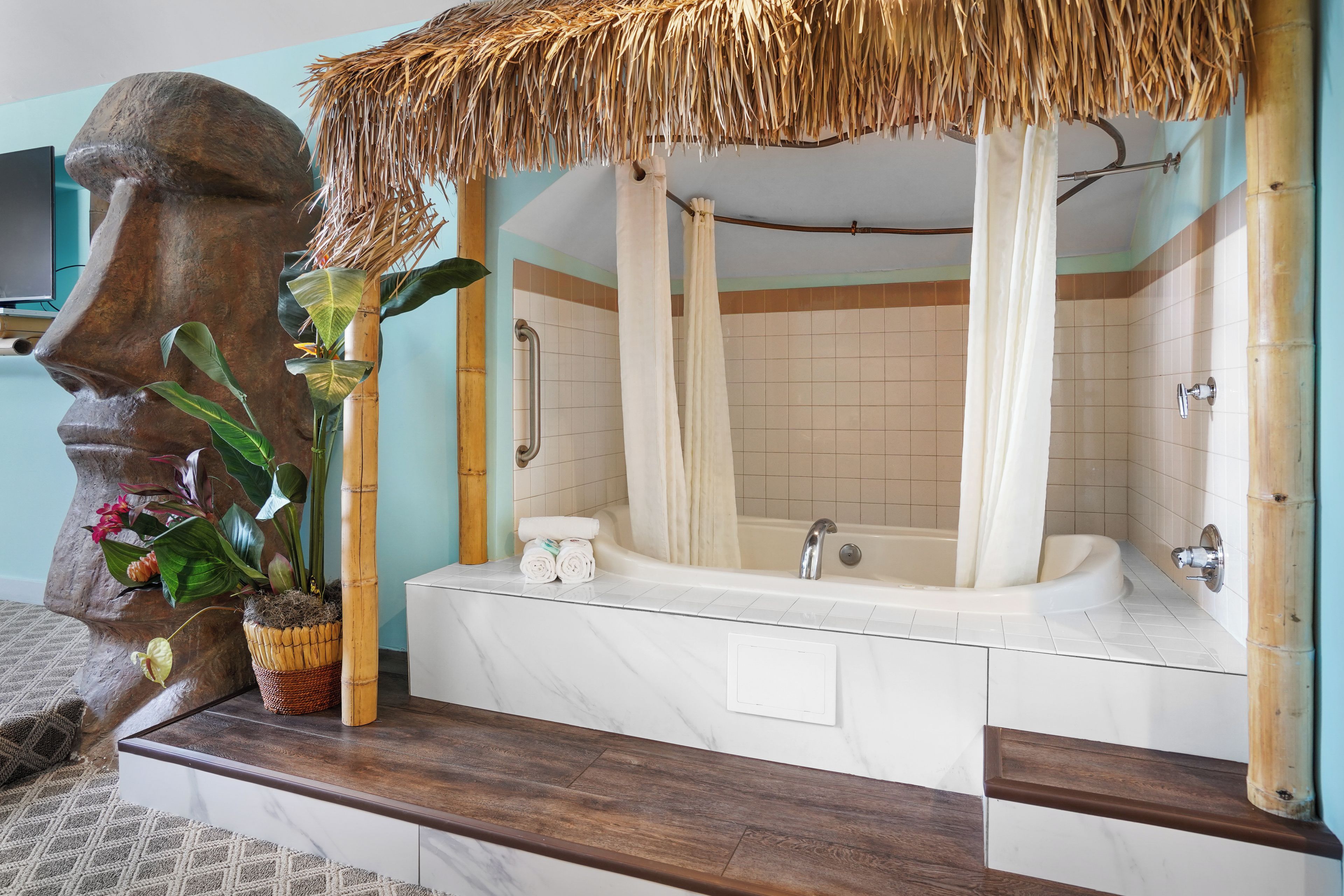 A bathroom with a large bathtub, a shower, and a vanity with a marble countertop.