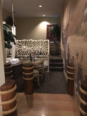 A narrow hallway with a patterned floor, a white decorative wall, and a staircase leading to a higher level. - Chateau Avalon Hotel & Spa (Kansas City)