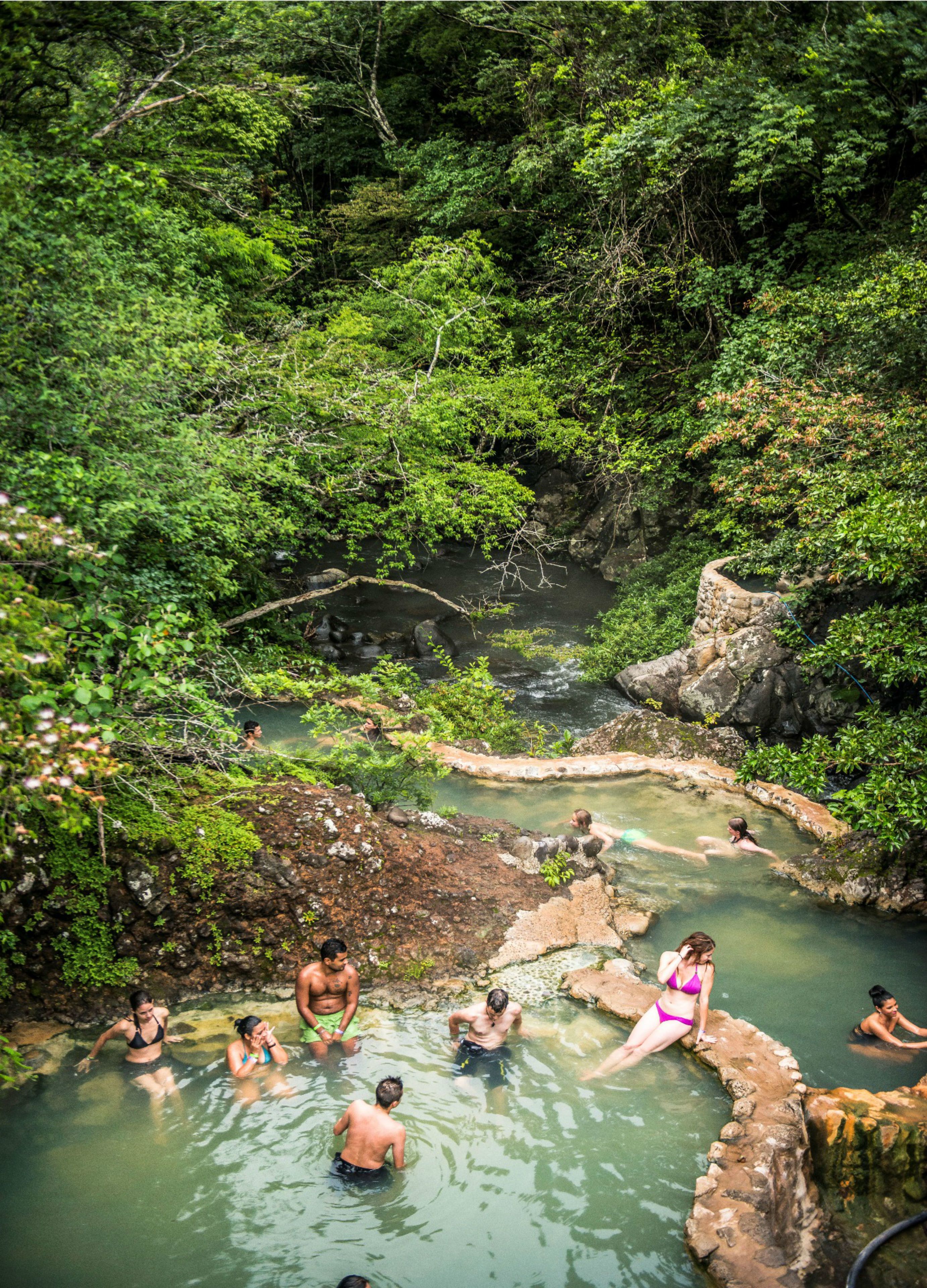 Une source d'eau chaude naturelle, entourée d'une végétation luxuriante.
