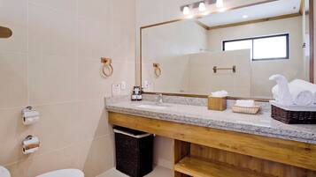 Un bagno moderno con un mobile bagno in legno, uno specchio grande e un water.