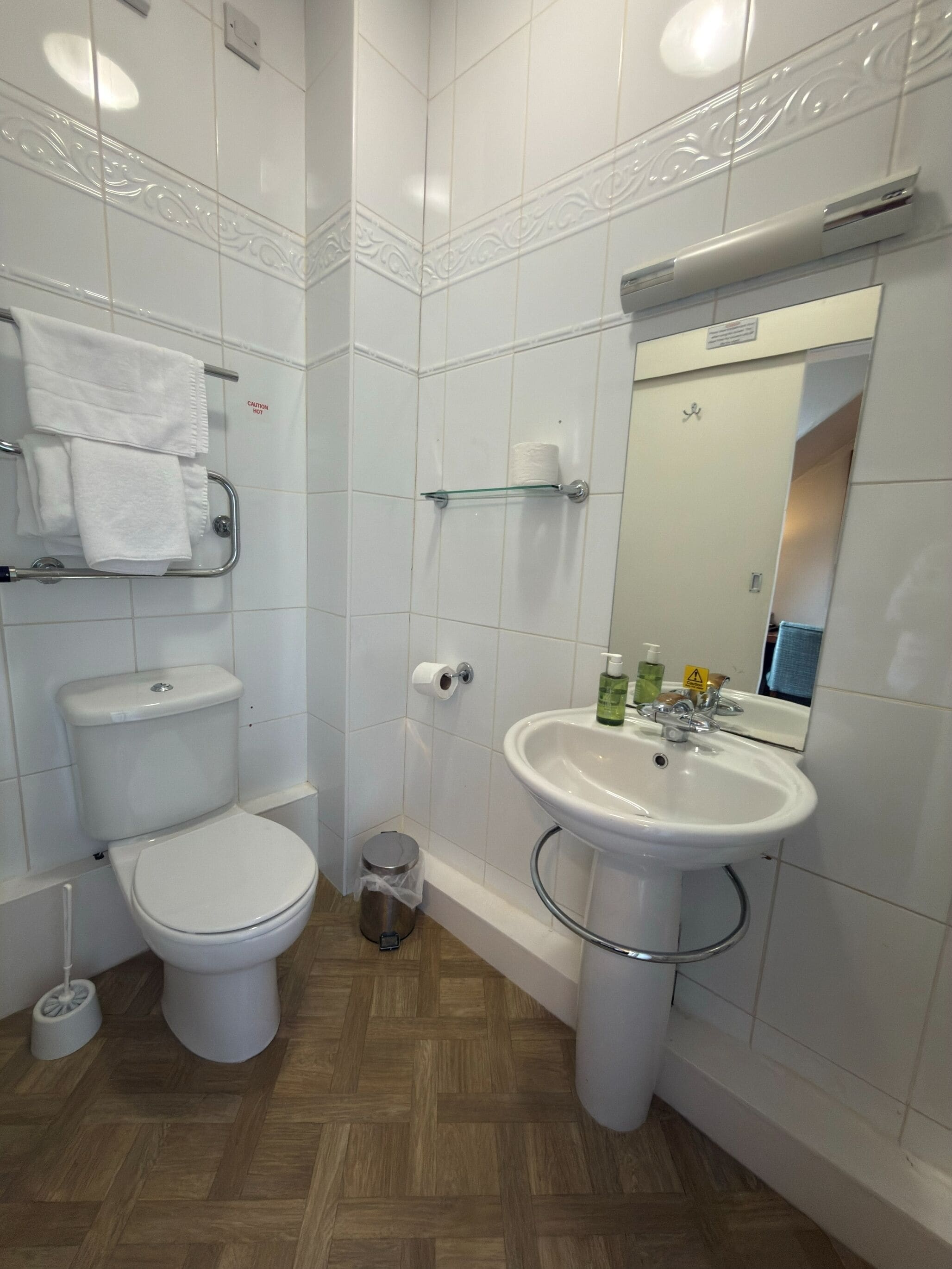 A modern bathroom with a toilet, sink, and mirror.