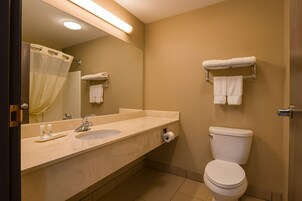 Un baño con lavamanos doble, inodoro y espejo.