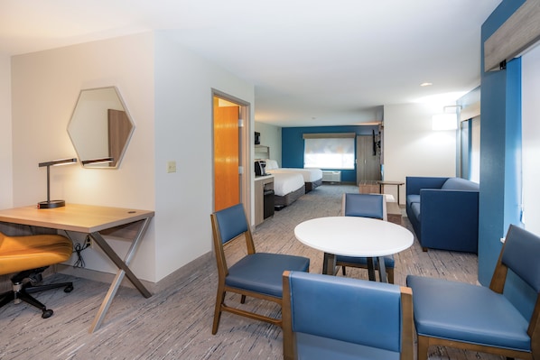 A hotel room with a desk, chairs, a round table, a bed, and a bathroom. - Holiday Inn Express Hotel & Suites Chanhassen by IHG (Chanhassen)