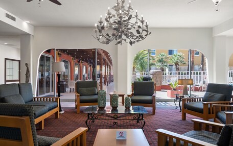 A lobby with a chandelier, seating area, and a view of the outside.