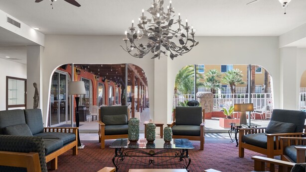 A lobby with a chandelier, seating area, and a view of the outside. - Hotel Americana (Nogales)