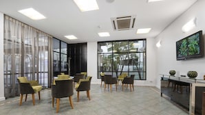 A modern conference room with a large window, a flat-screen TV, and a glass table. - Metro Hotel Perth City (East Perth)