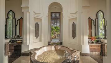 Relax in a spacious bathroom with a bathtub, double sink, and high ceilings.
