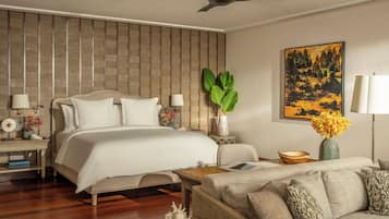 Une chambre d’hôtel moderne avec un grand lit, un canapé, une table basse et un tableau accroché au mur.
