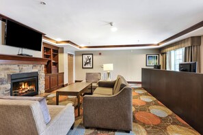 A hotel lobby with a fireplace, seating area, and a television. - Staybridge Suites Philadelphia-Mt. Laurel by IHG (Mount Laurel)