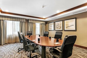 A conference room with a large table, six chairs, and framed artwork on the wall. - Staybridge Suites Philadelphia-Mt. Laurel by IHG (Mount Laurel)