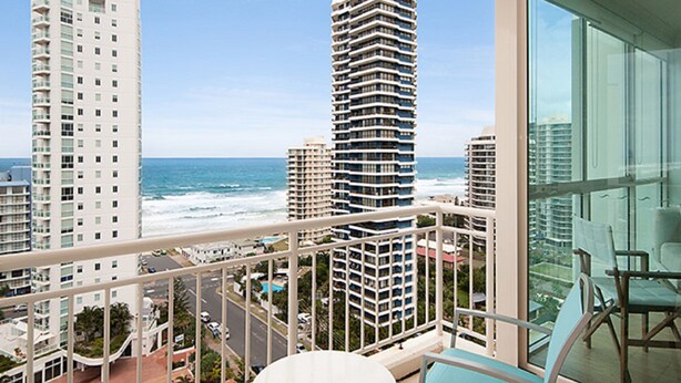 A balcony with a view of the ocean and tall buildings. - Maldives Resort (Main Beach)