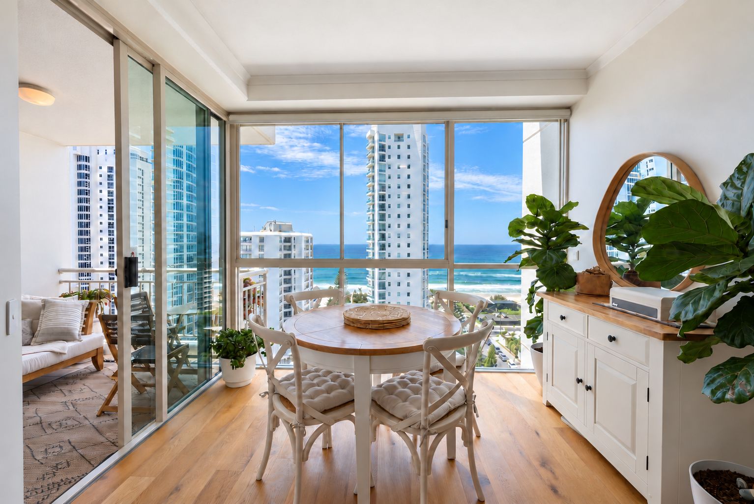 A modern room with a large window overlooking a cityscape and the ocean.