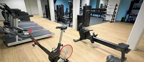 A gym with multiple exercise bikes, treadmills, and weight machines.