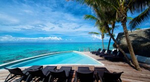 Alberca al aire libre y camastros 