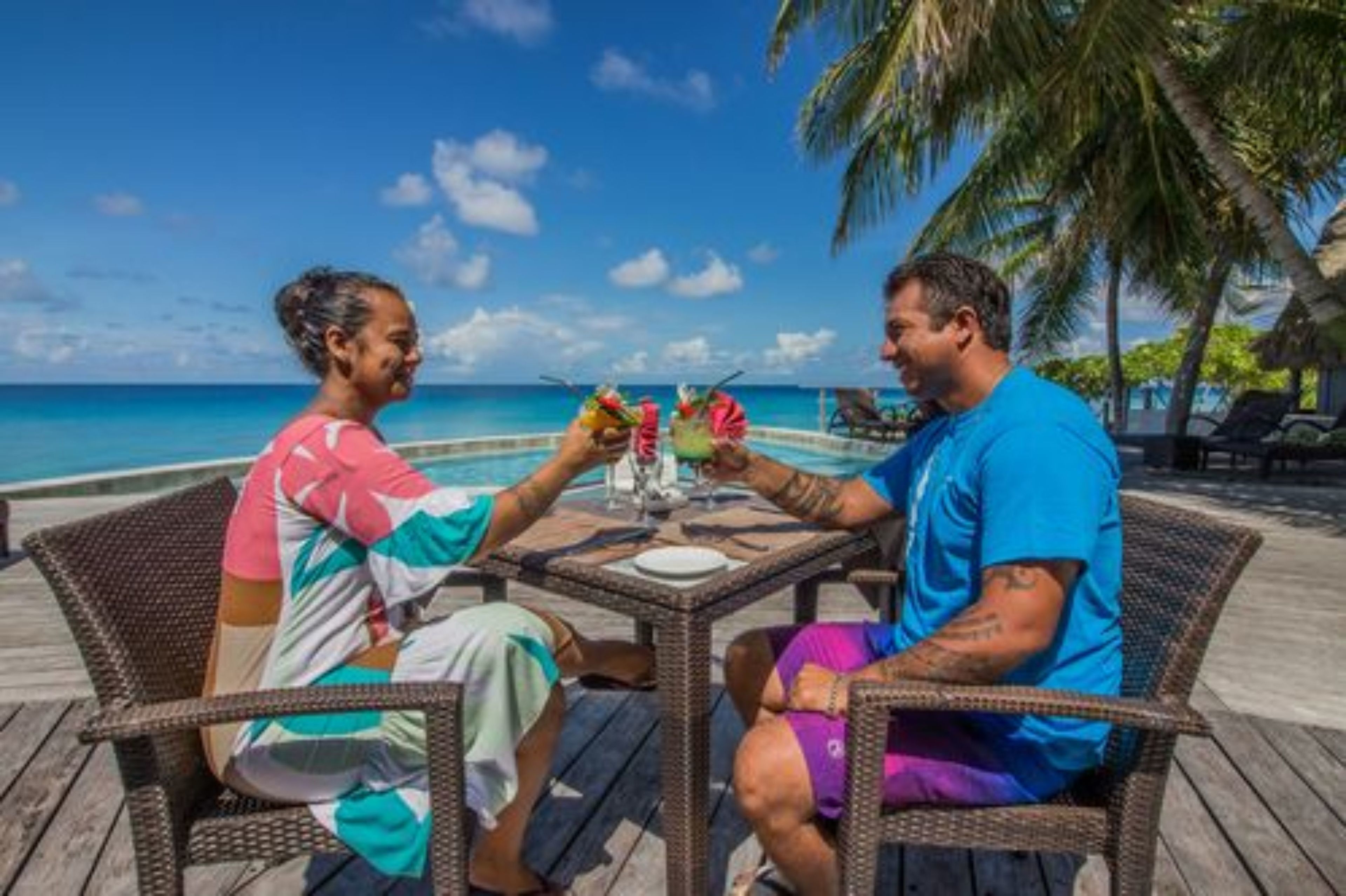 Two people dining at a table with a view of the ocean.