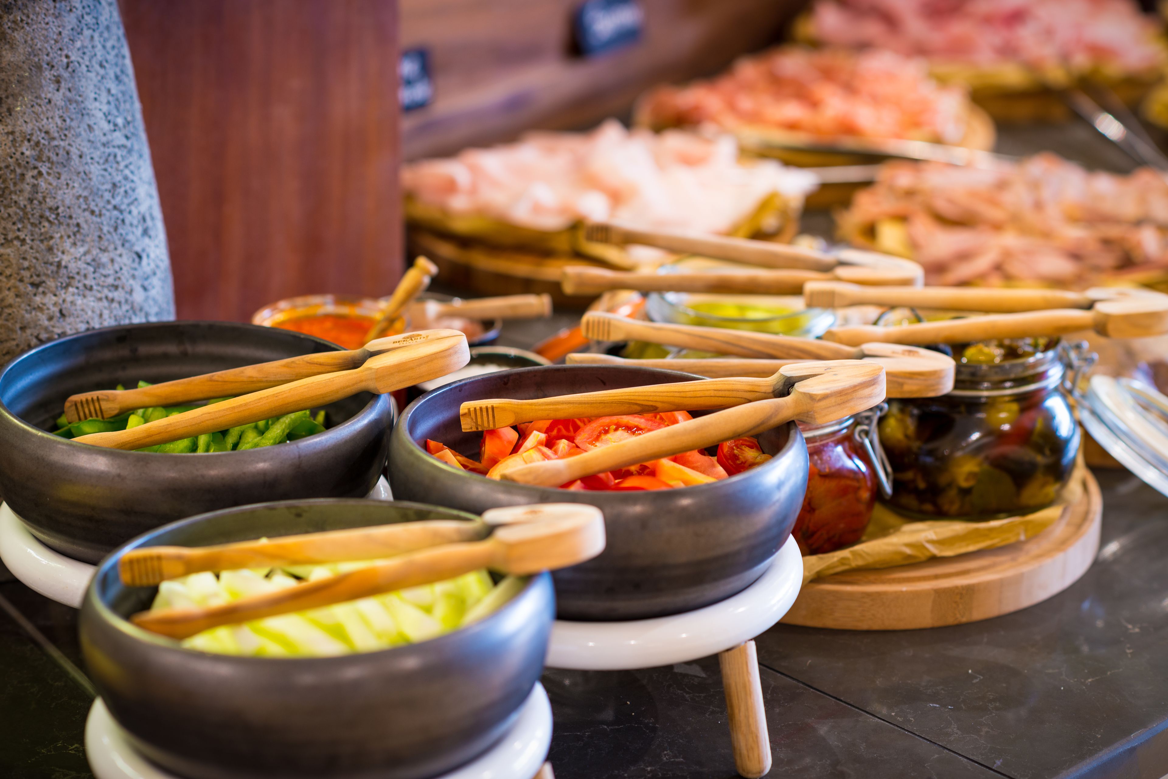 Un buffet con diversi cibi e utensili di legno.