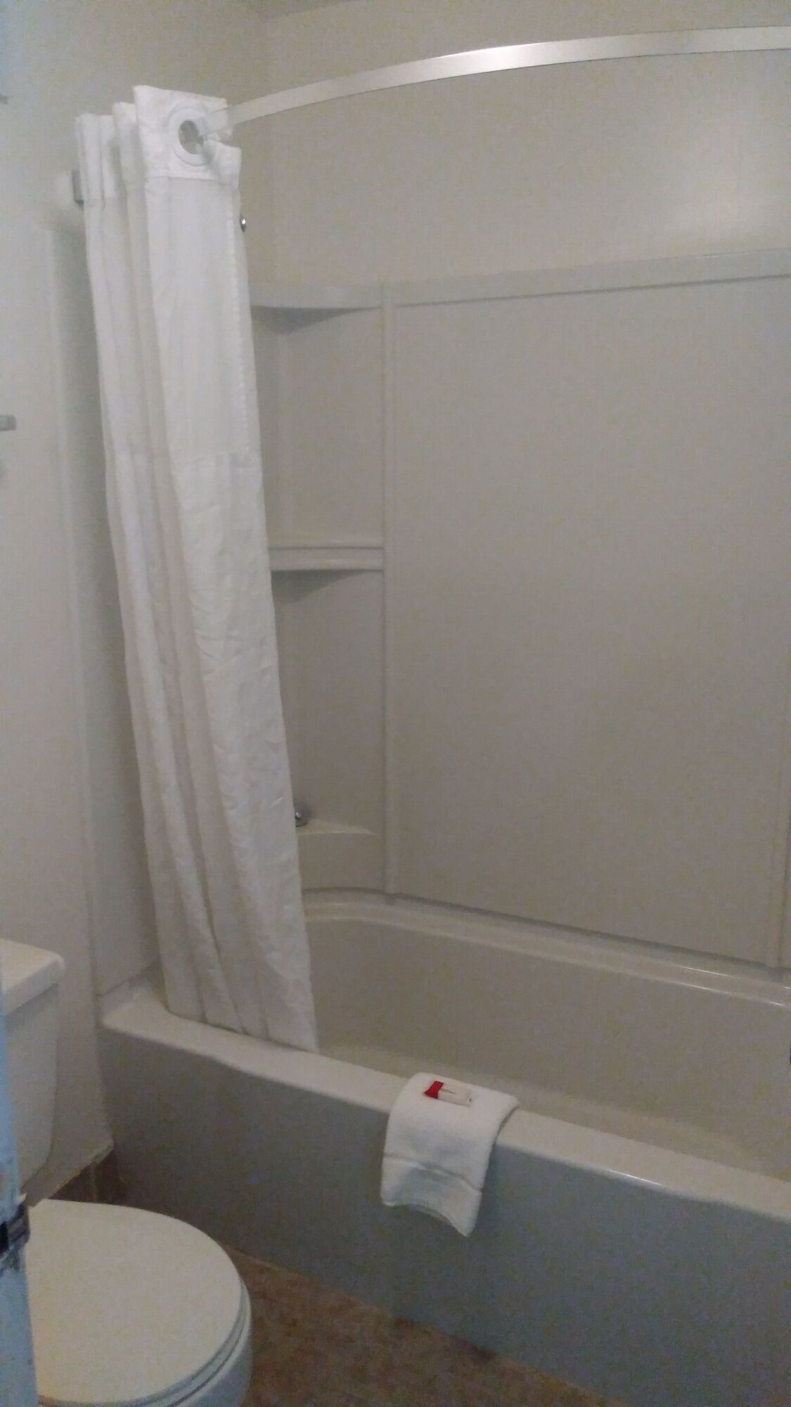 Un baño con bañera, inodoro y cortina de ducha.