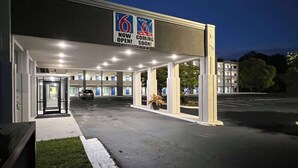 L’entrée d’un hôtel, avec une pancarte indiquant qu’il est désormais ouvert et qu’une ouverture prochaine est prévue.