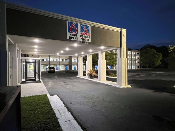 A hotel entrance with a sign indicating it is now open and coming soon. - Motel 6 West Columbia, SC - Airport (West Columbia)