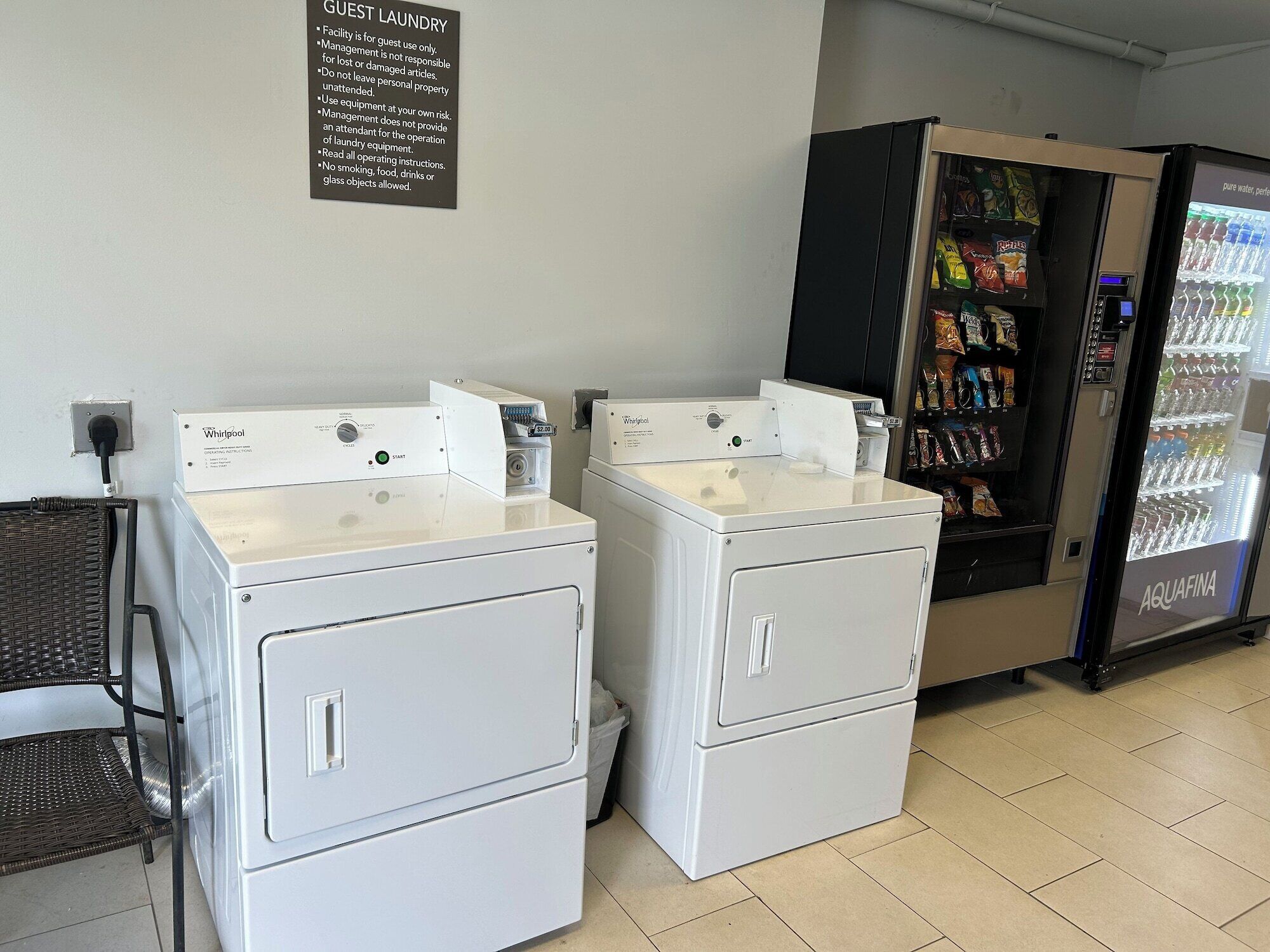 A laundry facility with Whirlpool washers and dryers, a vending machine, and a water cooler.