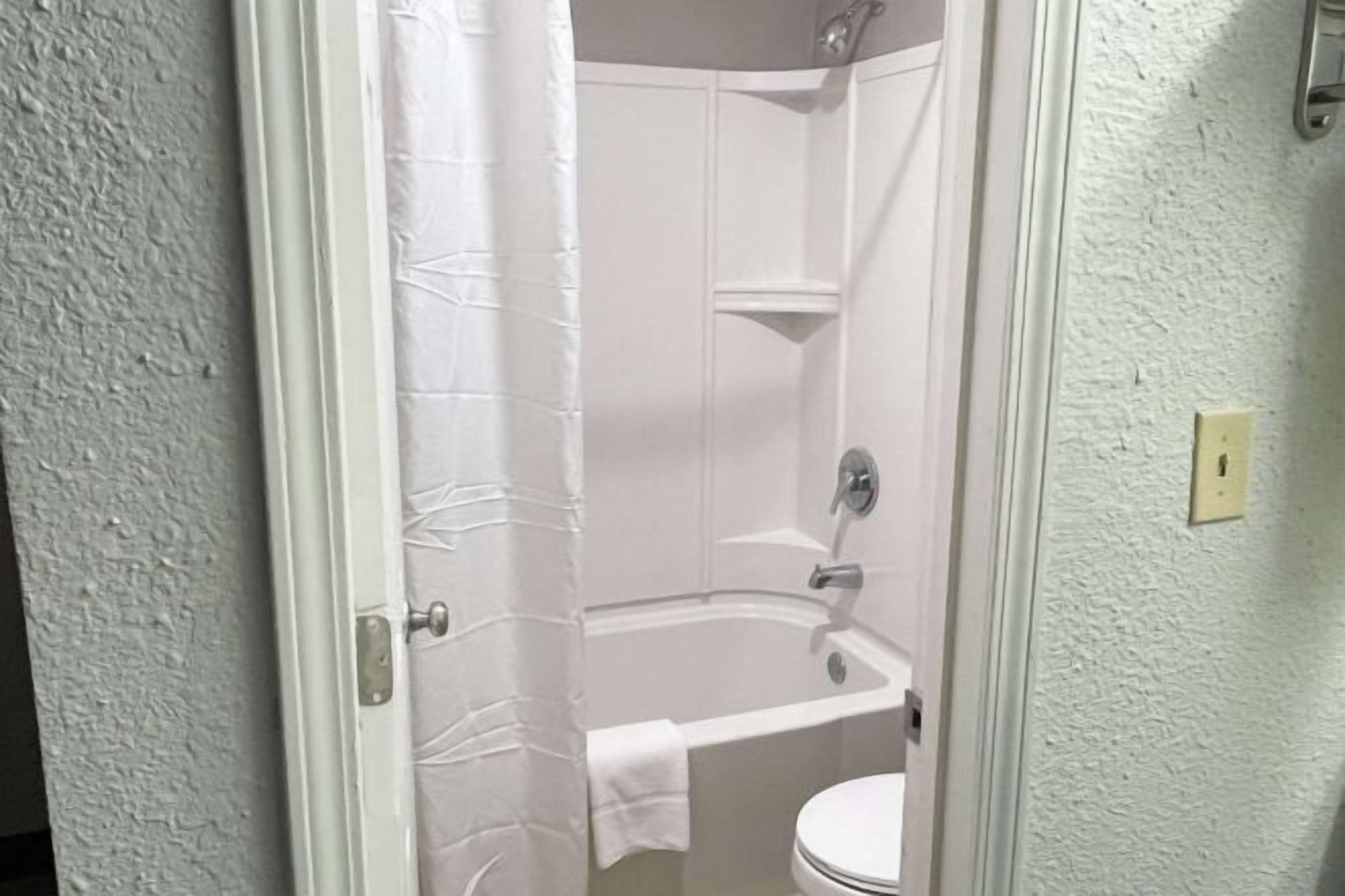 Een bad/douchecombinatie, gratis toiletartikelen, handdoeken