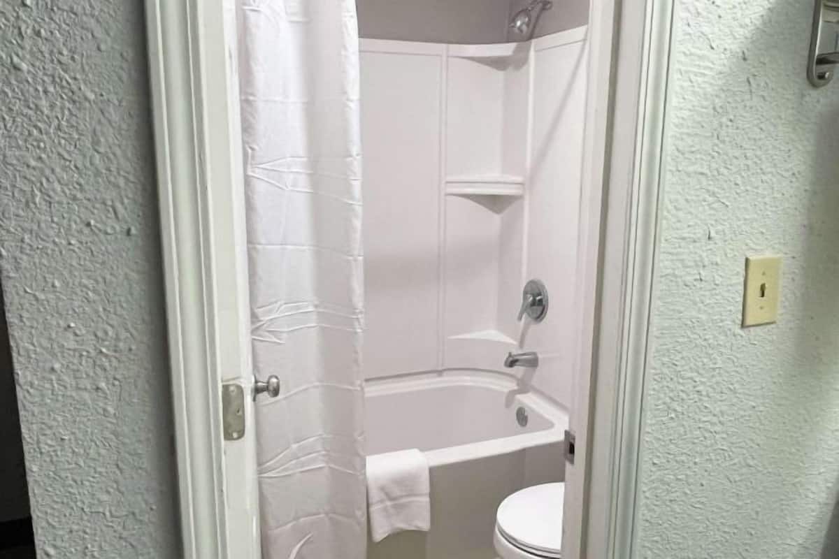 Tina con regadera, amenidades de baño gratuitas, toallas, papel de baño