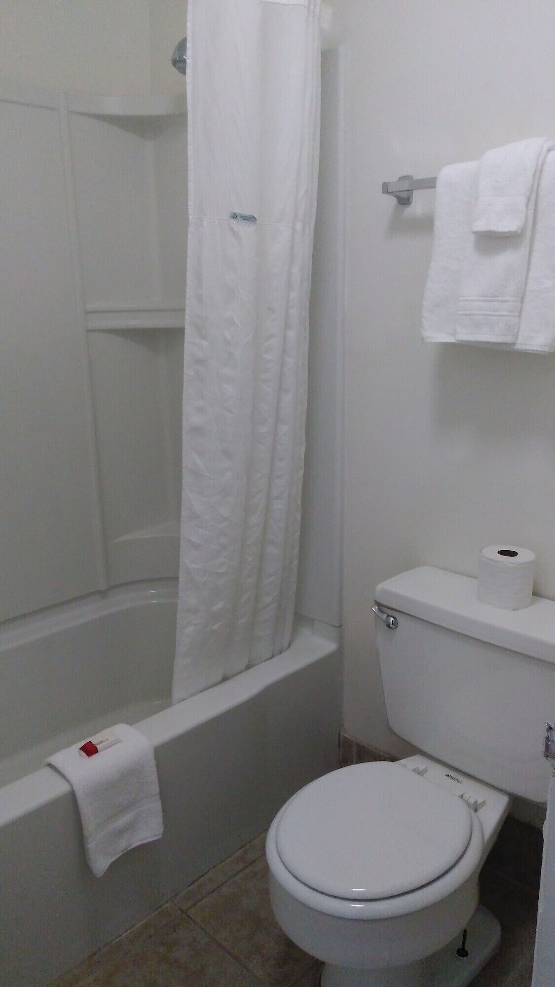Une salle de bain équipée d’une baignoire, de toilettes et d’un porte-serviettes.