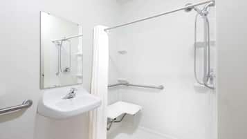 A bathroom with a white sink, mirror, and shower.