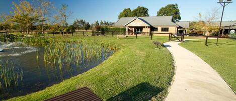 A park with a pond, a walking path, and a building labeled "Visitor Center".