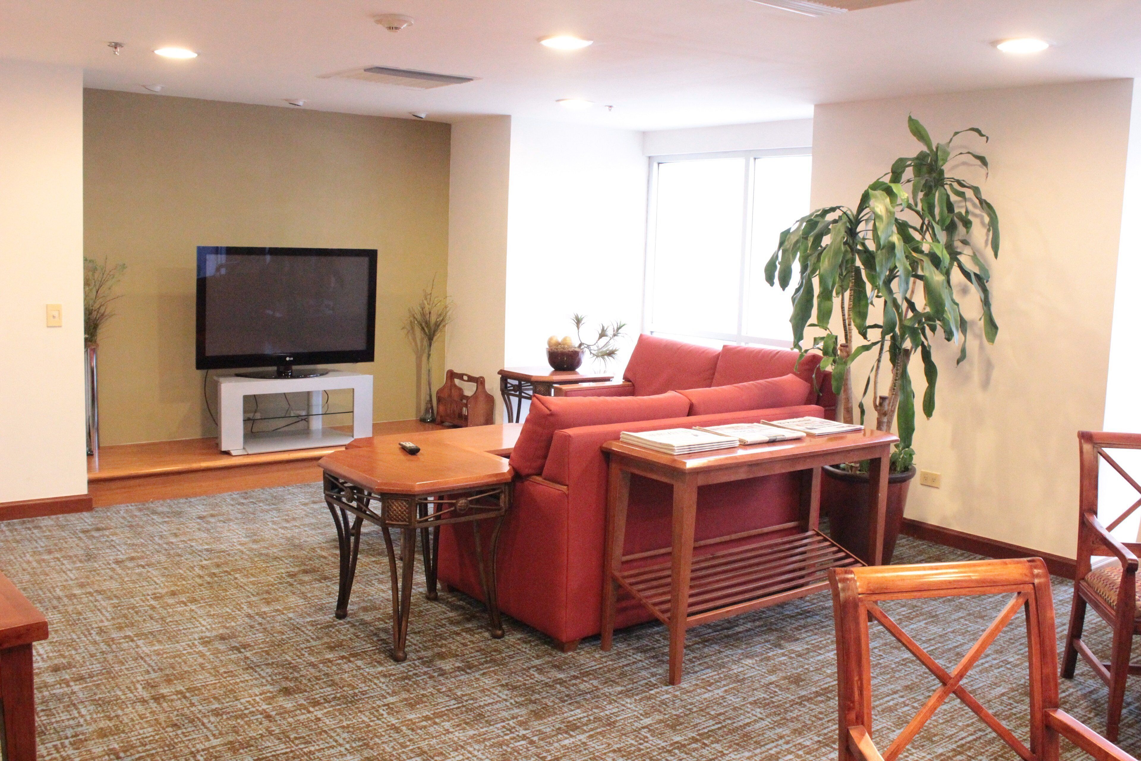 A living room with a television, sofa, coffee table, and chairs.
