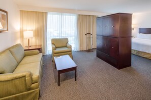 A hotel room with a sofa, armchair, a small table, a wardrobe, and a bed. - Holiday Inn Monterrey Valle by IHG (San Pedro Garza García)