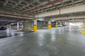 A multi-level parking garage with concrete pillars and yellow safety markings. - Holiday Inn Monterrey Valle by IHG (San Pedro Garza García)
