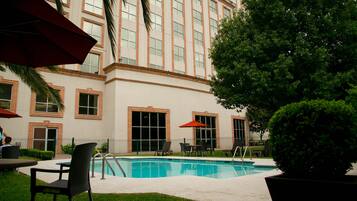 Relax by the pool surrounded by comfortable seating and shaded areas.