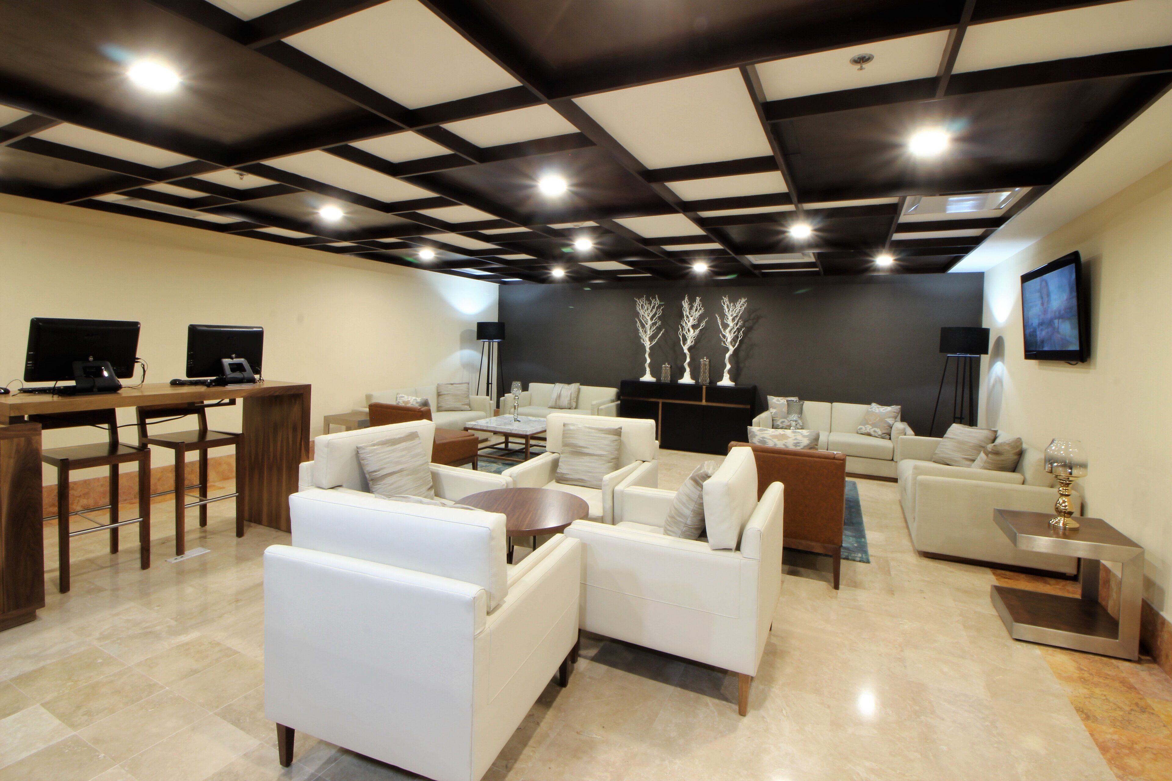 A spacious living area with multiple seating options, a flat-screen TV, and a modern ceiling design.