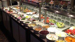 Un buffet proposant une variété de plats et agrémenté d’un mur décoratif.
