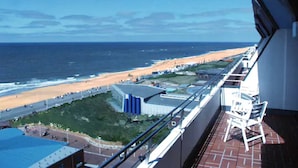 Un balcon avec vue sur une plage et l’océan.