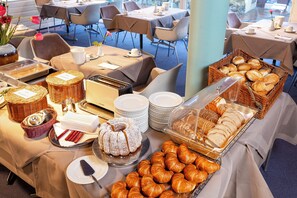A buffet setup with various food items and dining ware.
