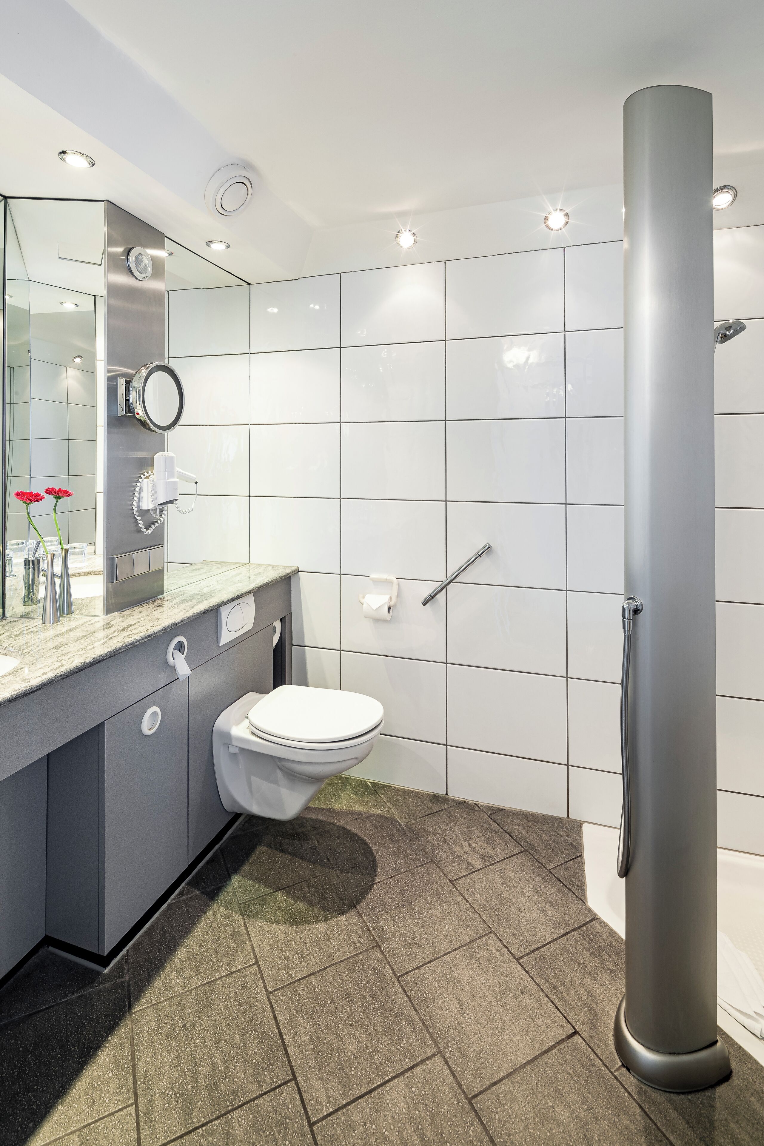 A modern bathroom with a toilet, sink, and shower.