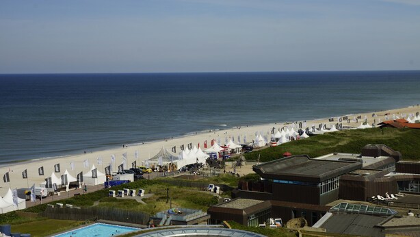 Un hôtel en bord de mer doté d’une piscine, de cabanes sur la plage et offrant une vue sur l’océan.