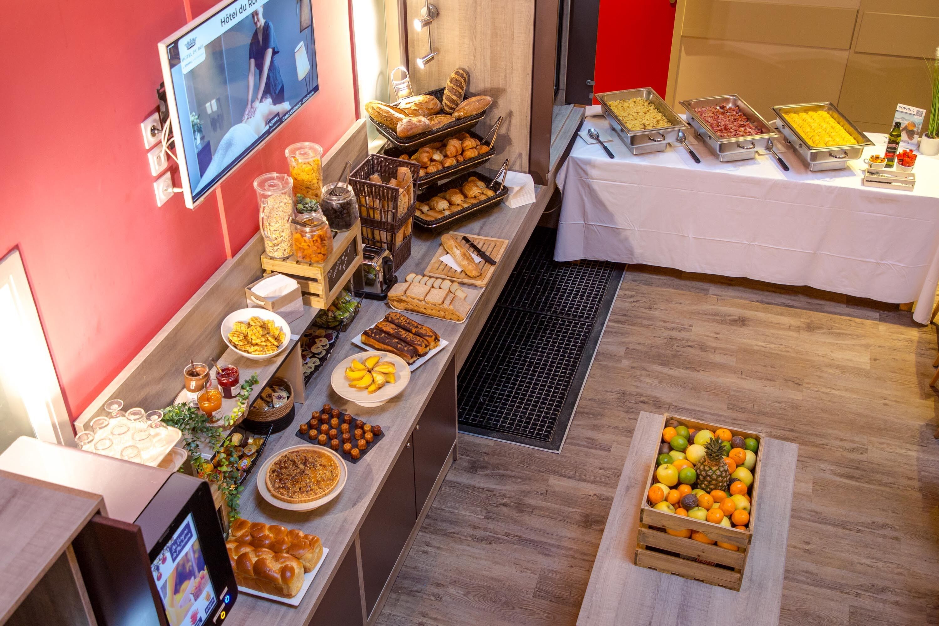 A buffet with various food items and a fruit display.